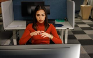 Focused woman working at a computer in a modern office cubicle