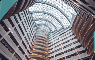 Modern multi-story atrium with curved balconies and glass ceiling