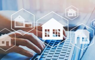 Hands typing on a laptop keyboard with digital house icons overlayed, representing online real estate search and property management.