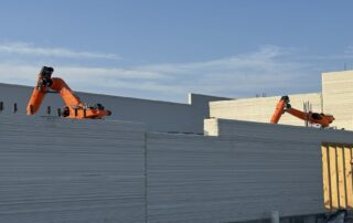 3d printing robots building concrete walls on a construction site