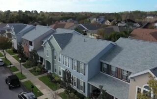 Florida’s Property Insurance Battle Heats Up As 2026 Approaches 6 Aerial view of a suburban neighborhood street lined with multi-story townhomes and parked cars.