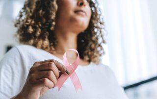 Woman holding a pink breast cancer awareness ribbon
