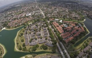 Aerial view of a suburban neighborhood with clusters of homes surrounding a series of lakes and canals.