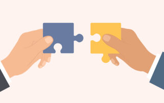 Two hands holding interlocking puzzle pieces to symbolize collaboration