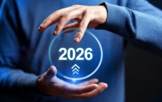Hands holding a glowing digital circle with the year 2026 and upward arrows.
