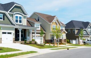Newly built suburban houses with garages along a curved residential street