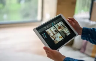 Person holding a tablet showing a multi-camera home security system interface