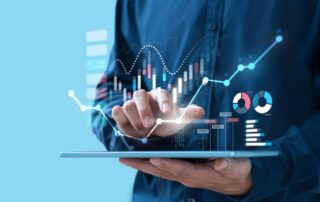 Business professional using a digital tablet with holographic charts and data analytics graphs displayed.