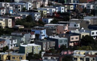 Colorful densely packed houses on a hillside in an urban neighborhood.