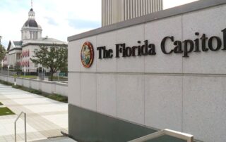 Florida state capitol building and entrance sign reading “the florida capitol”