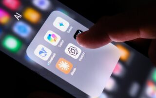 Finger tapping on a smartphone folder of ai assistant apps including gemini, copilot, deepseek, claude, and chatgpt.