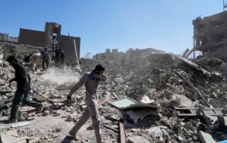 Rescue workers searching through rubble of collapsed buildings in a war‑torn city